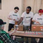 Volunteers distribute food and drinks to the needy at an outdoor charity event.